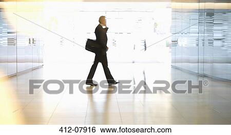 Businessman walking in lobby View Large Photo Image Stock Photograph - Businessman walking in lobby. Fotosearch