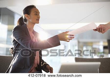 Businesswoman reaching for paperwork View Large Photo Image Stock Photo - Businesswoman reaching for paperwork. Fotosearch