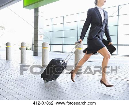 Businesswoman running with suitcase View Large Photo Image Stock Image - Businesswoman running with suitcase. Fotosearch