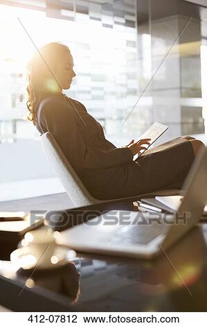 Businesswoman using digital tablet in office View Large Photo Image Stock Image - Businesswoman using digital tablet in office. Fotosearch