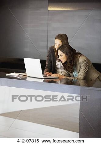 Businesswoman using laptop in lobby View Large Photo Image Stock Photography - Businesswoman using laptop in lobby. Fotosearch