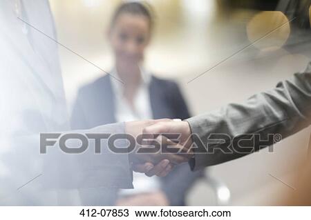 Stock Image - Close up of business people handshaking. Fotosearch