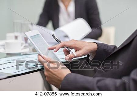 Close up of businessman using digital tablet in meeting View Large Photo Image Stock Photography - Close up of businessman using digital tablet in meeting. Fotosearch