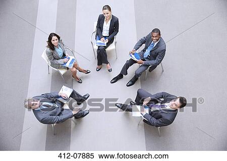 Stock Photography - High angle portrait of smiling business people meeting in circle. Fotosearch
