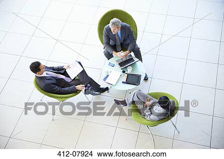 Picture - High angle view of business people meeting in lobby. Fotosearch