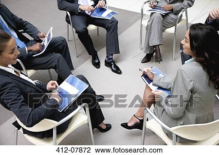 Stock Image - High angle view of business people meeting in circle. Fotosearch