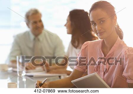 Portrait of confident businesswoman with digital tablet in meeting View Large Photo Image Stock Photo - Portrait of confident businesswoman with digital tablet in meeting. Fotosearch