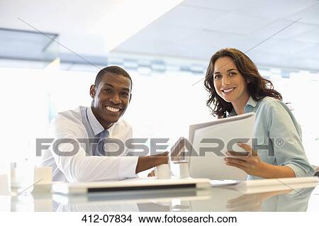 Portrait of smiling businessman and businesswoman working View Large Photo Image Picture - Portrait of smiling businessman and businesswoman working. Fotosearch