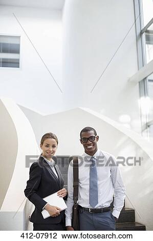 Portrait of smiling businessman and businesswoman at stairs View Large Photo Image Stock Image - Portrait of smiling businessman and businesswoman at stairs. Fotosearch