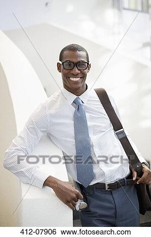 Stock Photograph - Portrait of smiling businessman on staircase. Fotosearch