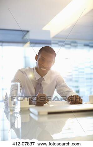 Portrait of smiling businessman working in office View Large Photo Image Stock Photo - Portrait of smiling businessman working in office. Fotosearch