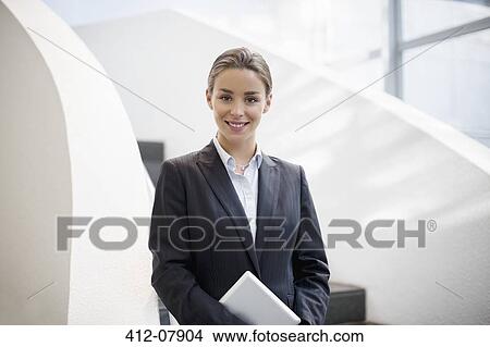 Picture - Portrait of smiling businesswoman holding digital tablet. Fotosearch