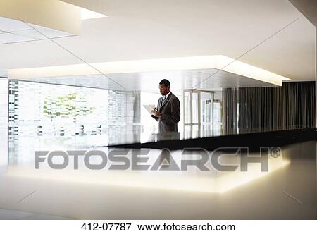 Silhouette of businessman with digital tablet in lobby View Large Photo Image Stock Photo - Silhouette of businessman with digital tablet in lobby. Fotosearch