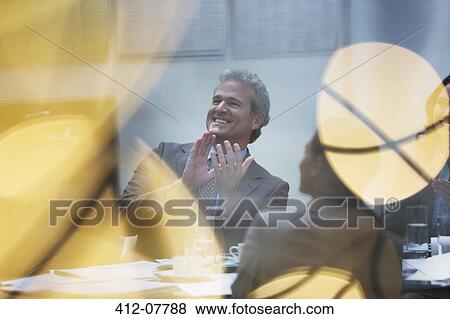 Smiling businessman clapping in meeting View Large Photo Image Stock Photo - Smiling businessman clapping in meeting. Fotosearch