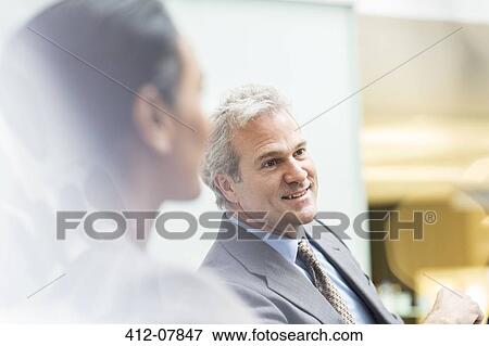 Smiling businessman in meeting View Large Photo Image Stock Photo - Smiling businessman in meeting. Fotosearch