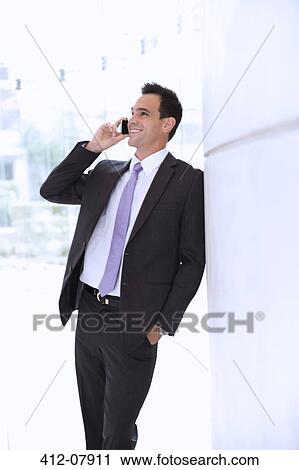 Smiling businessman talking on cell phone View Large Photo Image Stock Image - Smiling businessman talking on cell phone. Fotosearch
