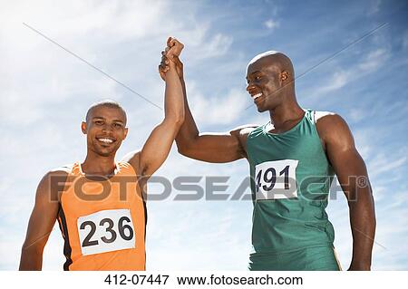 Stock Photo - Athletes celebrating together on track. Fotosearch