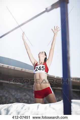 Stock Image - High jumper celebrating on other side of bar. Fotosearch