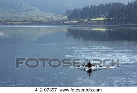 Stock Photo - Man rowing scull on lake. Fotosearch
