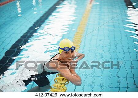 Portrait of smiling swimmer leaning on swimming lane marker in pool View Large Photo Image Stock Photo - Portrait of smiling swimmer leaning on swimming lane marker in pool. Fotosearch
