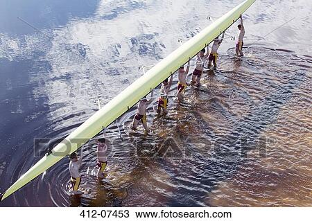 Rowing crew carrying scull overhead in lake View Large Photo Image Stock Image - Rowing crew carrying scull overhead in lake. Fotosearch