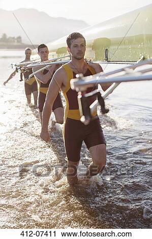 Rowing team carrying scull in lake View Large Photo Image Stock Image - Rowing team carrying scull in lake. Fotosearch