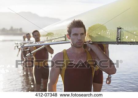 Rowing team carrying scull out of lake View Large Photo Image Stock Photo - Rowing team carrying scull out of lake. Fotosearch