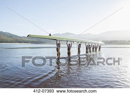 Rowing team holding scull overhead in lake View Large Photo Image Stock Image - Rowing team holding scull overhead in lake. Fotosearch