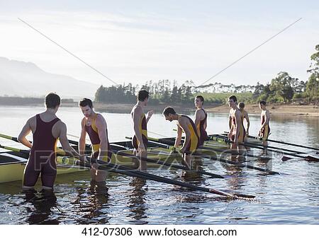 Rowing team placing boat on lake View Large Photo Image Stock Photograph - Rowing team placing boat on lake. Fotosearch