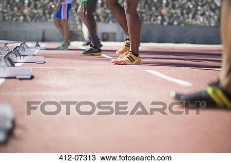 Runners standing at starting blocks on track View Large Photo Image Stock Image - Runners standing at starting blocks on track. Fotosearch