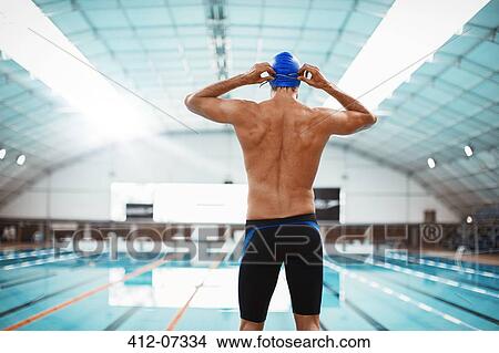 Swimmer adjusting goggles at poolside View Large Photo Image Picture - Swimmer adjusting goggles at poolside. Fotosearch