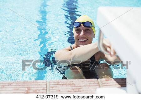 Stock Photo - Swimmer poised to start in swimming pool. Fotosearch