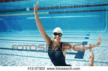 Stock Image - Swimmer posing underwater in pool. Fotosearch