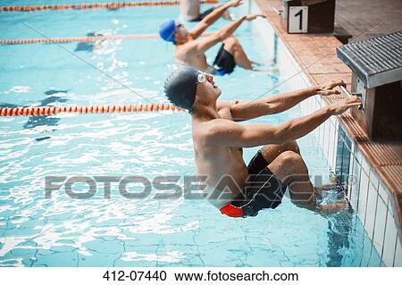 Swimmers poised at starting block in pool View Large Photo Image Stock Image - Swimmers poised at starting block in pool. Fotosearch