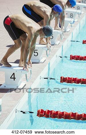 Swimmers poised at starting blocks View Large Photo Image Stock Photo - Swimmers poised at starting blocks. Fotosearch