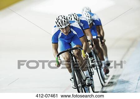 Stock Image - Track cycling team riding in velodrome. Fotosearch