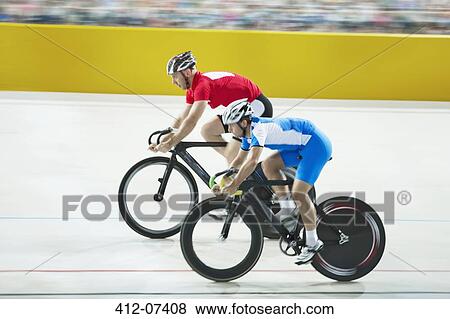 Stock Photo - Track cyclists racing in velodrome. Fotosearch