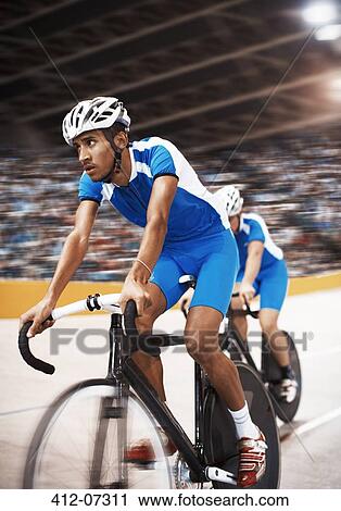 Stock Image - Track cyclists riding in velodrome. Fotosearch
