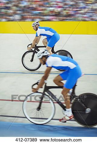 Stock Photo - Track cyclists riding in velodrome. Fotosearch