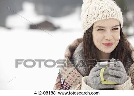 Close up of smiling woman in knit hat and gloves drinking coffee in snowy field View Large Photo Image Stock Photo - Close up of smiling woman in knit hat and gloves drinking coffee in snowy field. Fotosearch