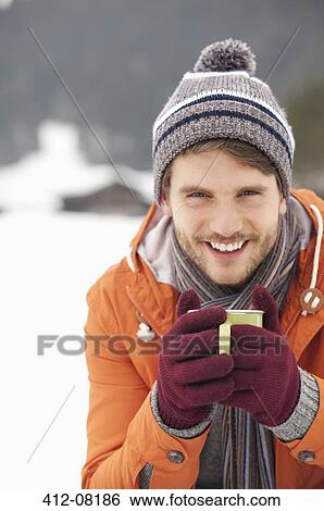 Close up portrait of smiling man in knit hat and gloves drinking coffee in snowy field View Large Photo Image Stock Photograph - Close up portrait of smiling man in knit hat and gloves drinking coffee in snowy field. Fotosearch