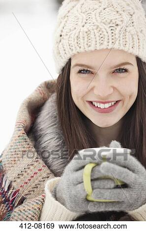 Stock Photo - Close up portrait of woman in knit hat and gloves drinking coffee. Fotosearch