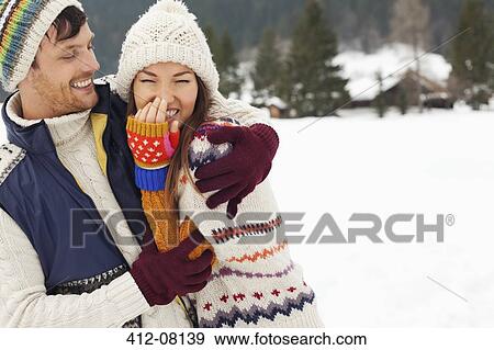 Couple laughing and hugging in snowy field View Large Photo Image Stock Photo - Couple laughing and hugging in snowy field. Fotosearch