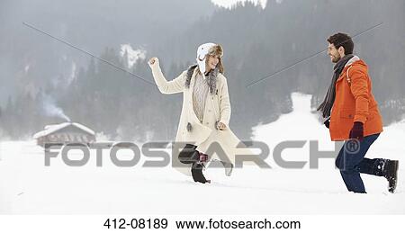 Couple running in snowy field View Large Photo Image Stock Photo - Couple running in snowy field. Fotosearch