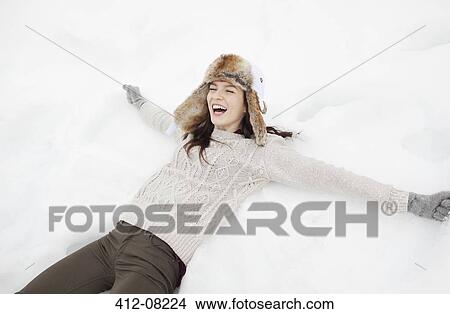 Picture - Enthusiastic woman making snow angel. Fotosearch