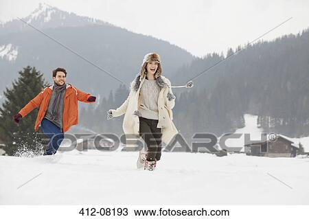 Happy couple running in snowy field View Large Photo Image Stock Image - Happy couple running in snowy field. Fotosearch