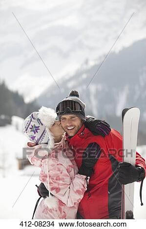 Happy couple with skis kissing in snowy field View Large Photo Image Picture - Happy couple with skis kissing in snowy field. Fotosearch