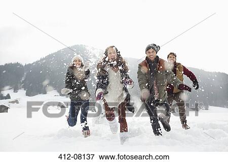 Happy friends playing in snowy field View Large Photo Image Stock Photo - Happy friends playing in snowy field. Fotosearch