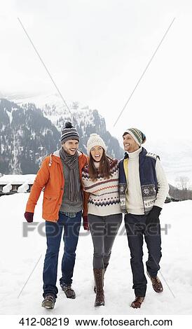 Stock Photo - Happy friends walking in snowy field. Fotosearch