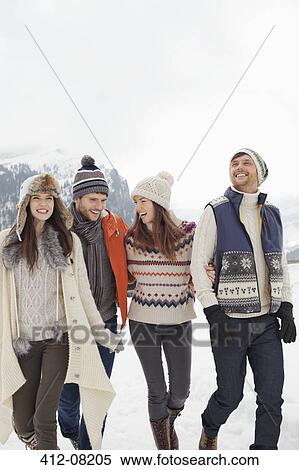 Stock Photography - Happy friends walking in snowy field. Fotosearch